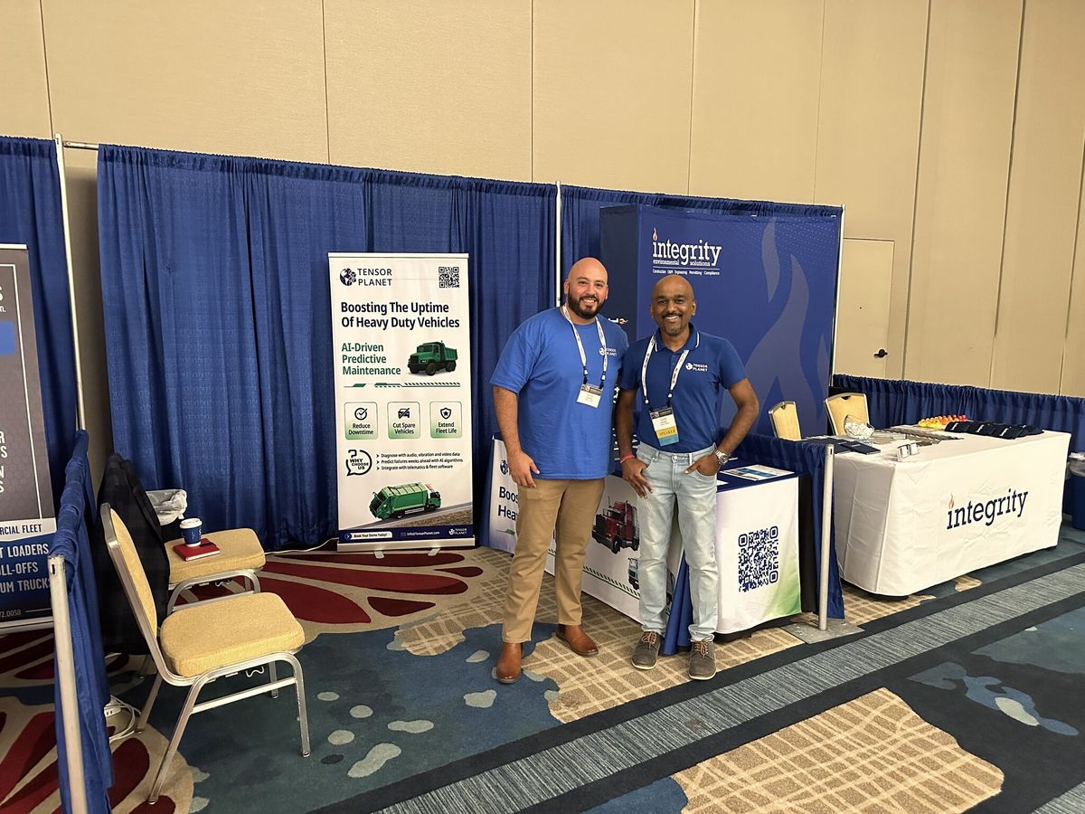Ganes Kesari and a colleague at the Tensor Planet booth, pull-up banner behind them