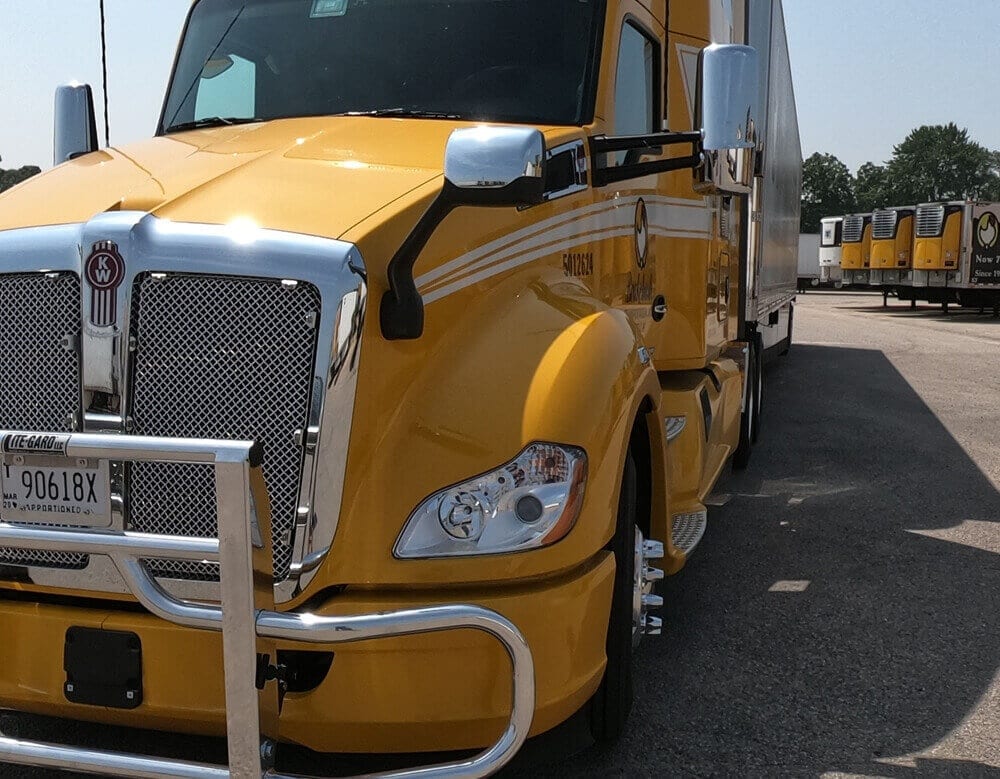 A Brakebush Transportation Kenworth tractor at the yard, with trailers lined up behind it