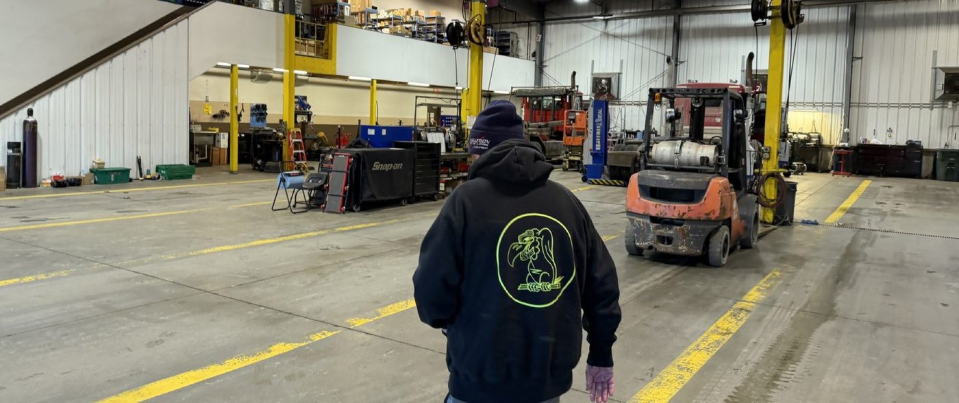 A Troiano Waste Services technician crossing the shop floor between service bays